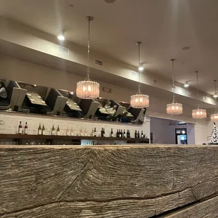a wooden bar with wine bottles on the counter