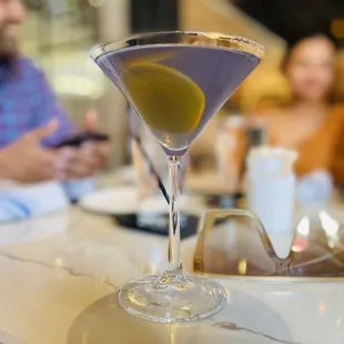 a martini in a martini glass on a bar