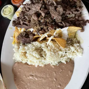 Chilaquiles with steak. (Also fluffy rice and amazing beans) with burning edges on the steaks