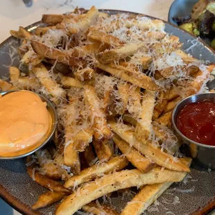 a plate of french fries with a side of sauce