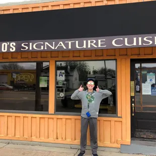 a man standing in front of a restaurant