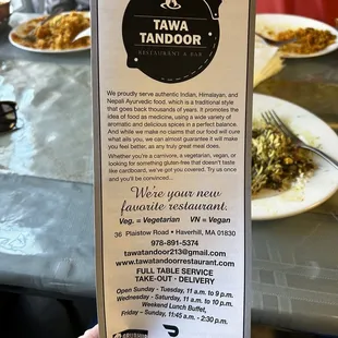 a hand holding a menu