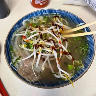 a bowl of soup and chopsticks