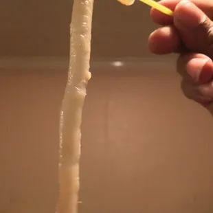 a hand holding a toothbrush and a tube of toothpaste