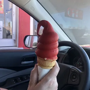Medium chocolate and vanilla twist cone with cherry flavored dip