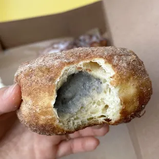 a hand holding a half eaten doughnut