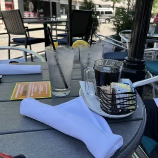 a table with glasses, napkins and a drink