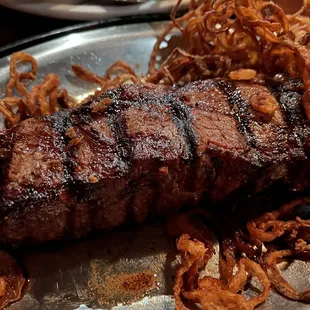 a steak on a plate with onion rings