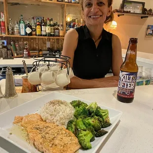 Chef Sandra at the bar serves her famous Cyprus Salmon with blackened broccoli and rice