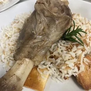 Braised lamb shank over a bed of vermicelli rice and garlic infused pita chips