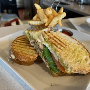 Grilled chicken panini with pesto, mozzarella, spinach, tomato, smashed avocado in a toasted sourdough panini. Served with fries