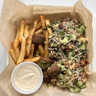 a tray of food with fries and a side of sauce