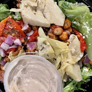 a salad with cheese, lettuce, tomatoes, and chickpeas