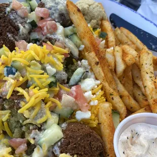 Fries, falafel bowl with saffron rice, tomato, cucumber, garlic Parmesan sauce, with feta amd hummus.