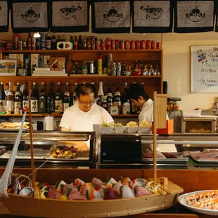 a man behind a sushi bar
