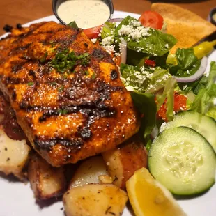 Salmon over potatoes and a side salad