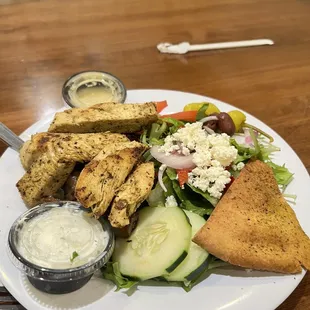 Grilled chicken feast with potatoes and Greek salad