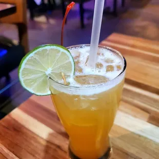 a drink with a straw and a lime slice