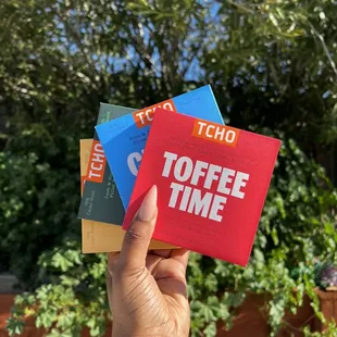 a hand holding three toffee time chocolates