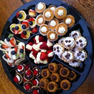 A large custom dessert appetizer tray with some seasonal items, such as mini pumpkin cheesecakes and pumpkin blossom cookies.
