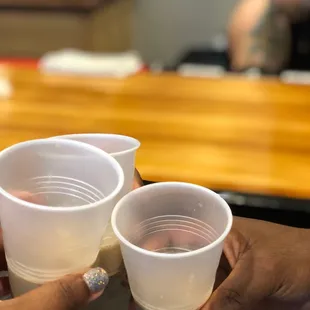two people holding plastic cups