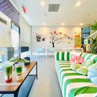 a green and white striped couch in a brightly decorated office