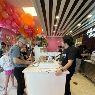 a man serving customers at a restaurant