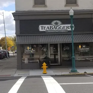 a yellow fire hydrant on the corner of a street