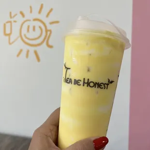 a hand holding a cup of iced tea