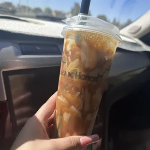 a hand holding a cup of iced coffee
