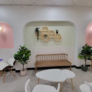 a white room with pink walls and white chairs