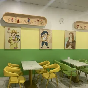 tables and chairs with artwork on the wall