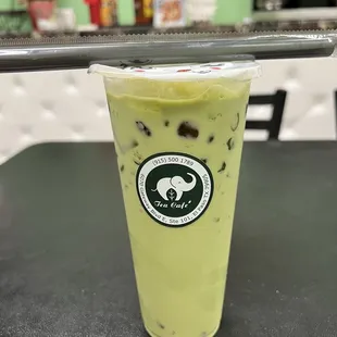  a green tea drink in a plastic cup