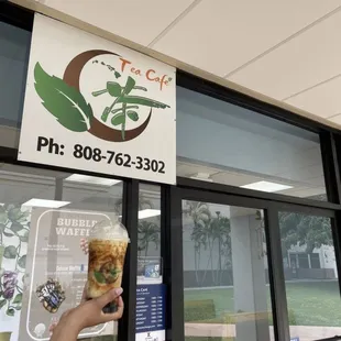 a hand holding a cup of iced coffee