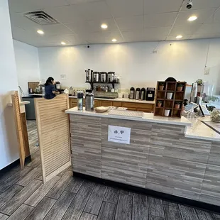 a coffee shop counter with a person in the background