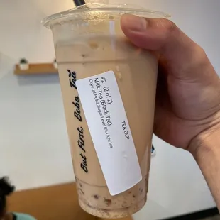 a hand holding a cup of iced coffee