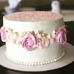 a white cake with pink roses