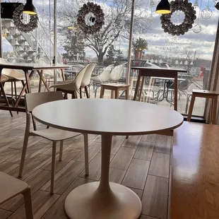 a table and chairs in front of a large window
