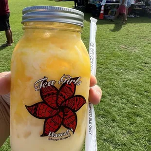 a hand holding a jar of iced tea