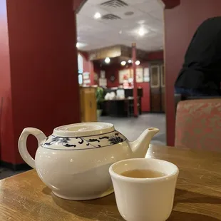 a tea pot and cup on a table