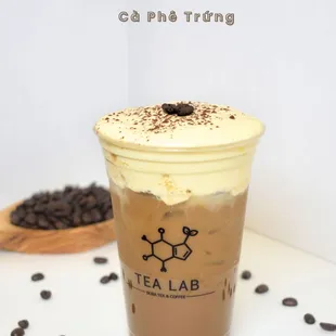 a cup of iced coffee with whipped cream and coffee beans