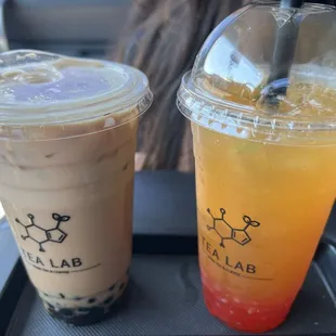 Black milk tea and boba  with 50% sugar and a peachy green tea and strawberry poppers.