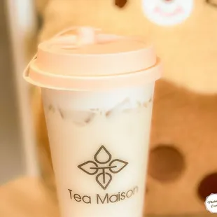  a cup of iced tea next to a teddy bear