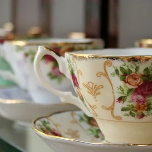 a row of tea cups and saucers