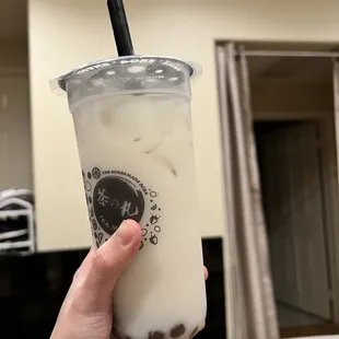 a hand holding a cup of boba