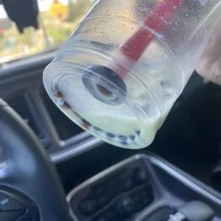 a person pouring a drink into a cup