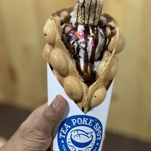 a hand holding a cup of ice cream