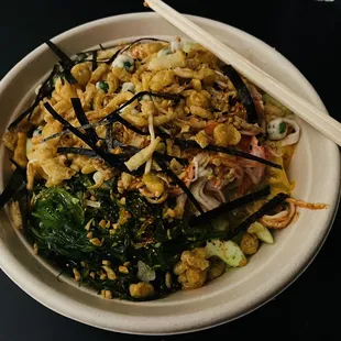 a bowl of food with chopsticks