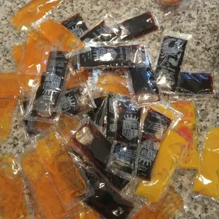 The pile of condiment packets for four entrees.