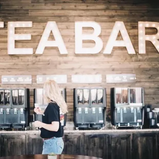 a woman standing in front of a tea bar